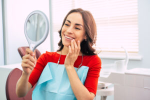 A woman looking in the mirror while sitting in a dentist’s chair